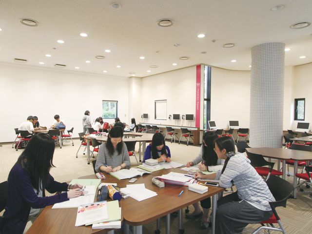 ■グループ・ラーニング・エリア：組み合わせ自由なテーブルは学生同士のミーティングや学習に利用しています。休み時間はたくさんの学生でとてもにぎやかです。