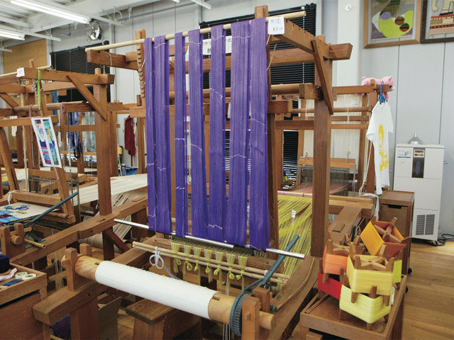 織物室。染織の中でも織工芸、織物の自主製作をする施設です。高機などの織り機を多数設置。他にも羊毛を圧縮してフェルトを作ったりソーイングや着物の製作もします。