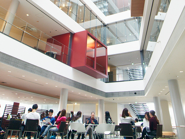［CUBE(西宮キャンパス)］5階から9階まで吹き抜けのアトリウムは学生の交流の場です。300インチの大画面を備え、プレゼンテーション大会等も開催しています。