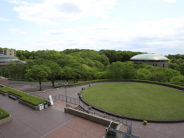 【多摩キャンパス／円形芝生】円形の芝生スペース。食事やおしゃべりなど、学生が思い思いに過ごす