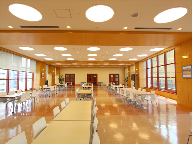 【小倉キャンパス】ラウンジ。授業の合間や昼休み、放課後に学生たちが利用するスペース。昼食をとったり、仲間同士で談笑したりと、学生たちは思い思いに利用しています。