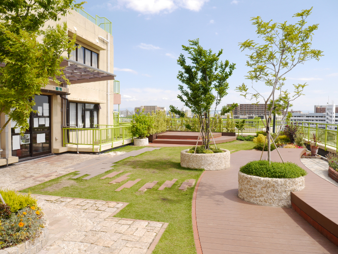 屋上庭園　　学生デザインで施工した庭園。植栽のほか、ウッドデッキや芝生スペースなど休憩スペースも設けている。